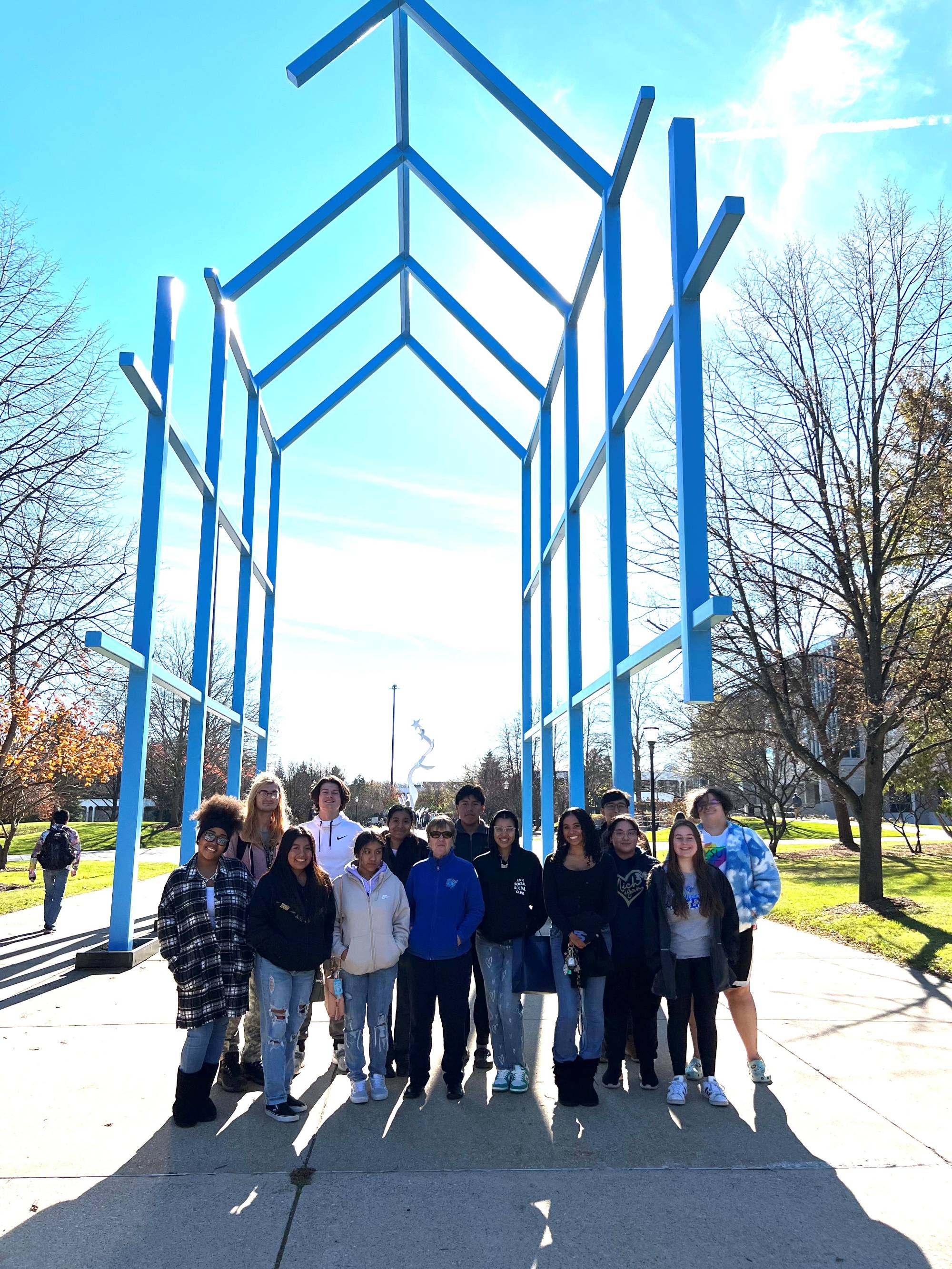 group of students in front of blue sculpture